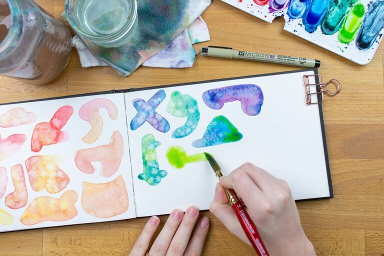 Hand painting blue and green watercolor blobs on page